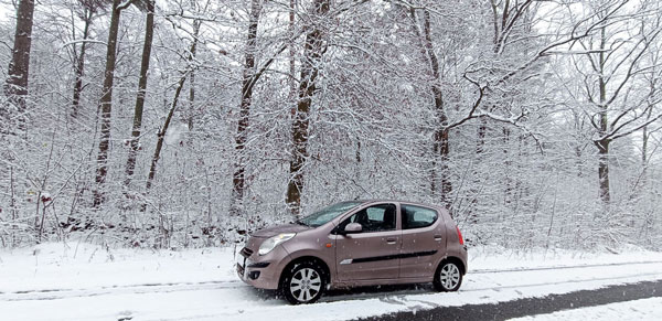 Автомобіль Suzuki Alto 2010 на засніженій дорозі в лісі 