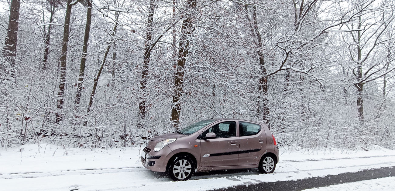 Автомобіль Suzuki Alto 2010 на засніженій дорозі в лісі 
